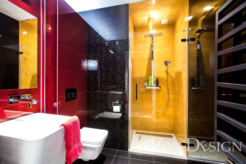 Żółta czerwona i czarna płytka w łazience z prysznicem