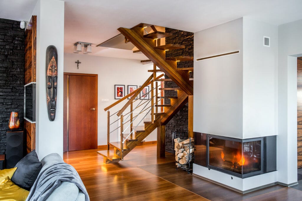 Drewniane schody na piętro wraz z kominkiem