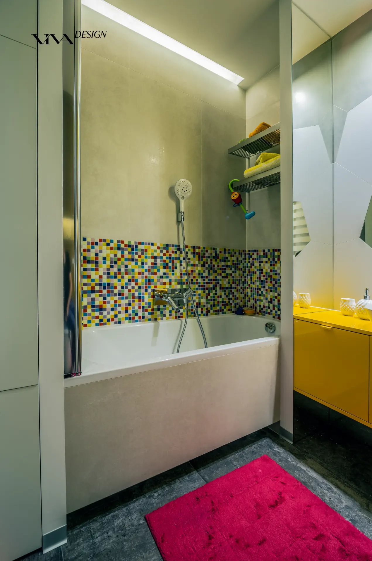 Kolorowa mozaika w łazience nad wanna oraz żółtą szafką